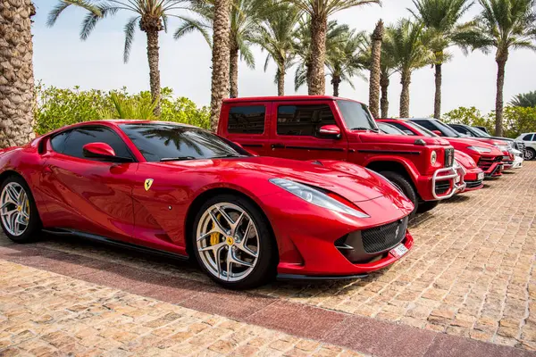 Dubai, Birleşik Arap Emirlikleri 10 Şubat 2021 - Dubai 'de otelin yakınına park edilmiş lüks modern arabaların yanında kırmızı bir Ferrari arabası.