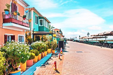 Yunanistan 'ın Lefkada kentindeki gezinti alanında renkli binalar ve saksılarla dolu güzel bir manzara. Turistik yerler.