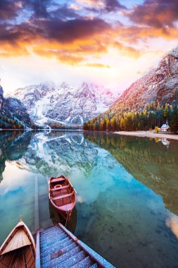 Günbatımında İtalya 'nın Dolomitler Alpleri' ndeki Fanes-Sennes-Braies doğal parkındaki gölde teknelerle büyüleyici bir sonbahar manzarası. (iç huzur, ahenk - kavram)