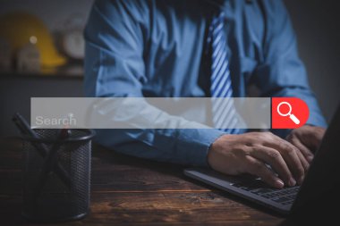 Ahşap tablolardaki internet verilerini araştırmak için dizüstü bilgisayar ya da bilgisayar kullanan bir iş adamı. İnternet dijital çevrimiçi, SEO, Networking konsepti. Arama kutusu simgesi olan toplum web sayfası ve boşluk kopyala.