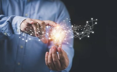 Yaratıcılık yeniliği yeni teknoloji ve gelecekte iş için yeni fikirler. İş adamı elinde ampulü teknoloji ağı dijital ağıyla tutuyor.