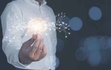 Teknolojinin internet dijital ağlarını kullanarak şirketin geleceğine yeni bir iş kurmak için yaratıcı fikirler. Elinde beyin simgesi olan bir ampul tutan bir iş adamı..