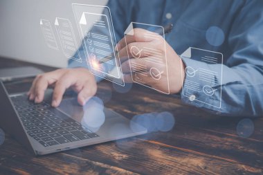 Belge yönetimi, ofis kağıtsız fikirler, elektronik imza konsepti. İşadamı elektronik bir belgeyi imzalamak için bir kalem kullanıyor. Tahta bir masada dizüstü bilgisayarı var..