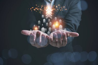 İş adamı elinde tutarken şirketlerin ok grafiği büyümesini geleceğe taşıyor. Şirkette kar elde etmek için işlerin gelişmesi. Yatırım, finans, iş konsepti.