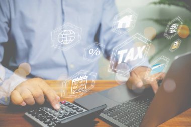 İş adamı, geri ödeme değeri vergisini hesaplamak için bir hesap makinesi kullanır ve yatırım gayrimenkulleri için maliyeti ve kârı online hesaplamak için dizüstü bilgisayar kullanır. Yatırım, mali ve iş konsepti.