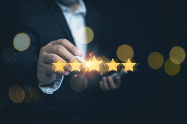 Müşteri memnuniyeti kavramı. İşadamı, müşteri hizmetleri mükemmelliği için beş altın yıldıza dokunuyor. Müşterinin ürün ve hizmet kullanmasından sonra değerlendirme anketi.