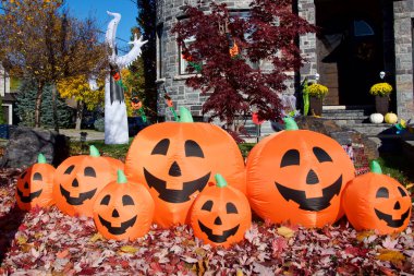 Ön bahçesinde Cadılar Bayramı süslemeleri olan bir ev.