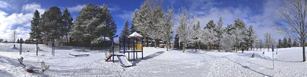 Panoramic photo of the slide - Kids\' play area equipment covered with snow in the public park. Web banner