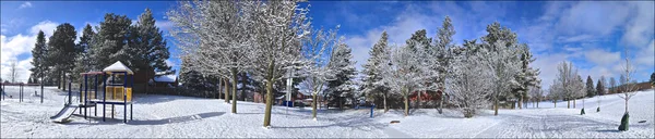 Panoramic photo of the kid\'s play area covered with snow in the public park. Web banner