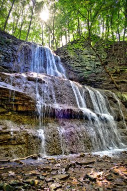 Low-angle view of a waterfall with lens flare