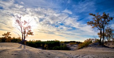 Sunset over the sand dune with dramatic sky. 