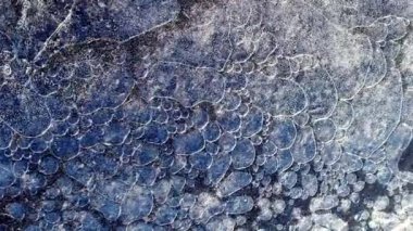 Water under an ice surface with air bubbles. 