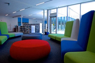 Toronto, Ontario / Kanada - 02 Haziran 2018: Halk kütüphanesinde sıralı kitaplıklarla dolu renkli mobilyalar. Öğrenim ve eğitim kavramı.