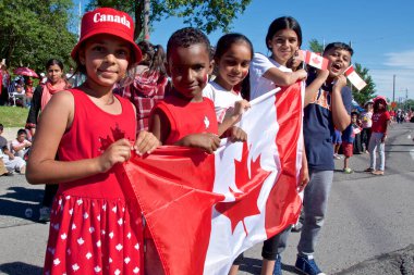 Toronto, Ontario / Kanada - 01 Temmuz 2019: Kanada Günü geçit töreninde ulusal bayrakları tutan çocuklar