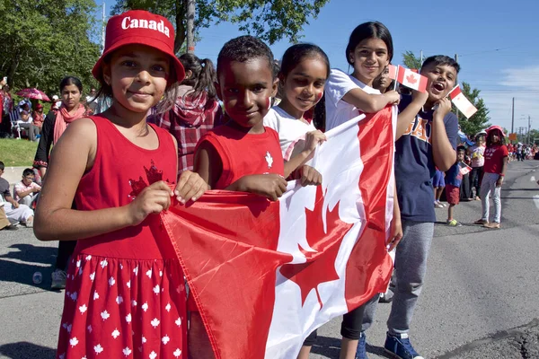 Toronto, Ontario / Kanada - 01 Temmuz 2019: Kanada Günü geçit töreninde ulusal bayrakları tutan çocuklar