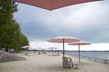 Toronto şehir merkezindeki pembe plaj şemsiyeleri ve Adirondack sandalyeleri.