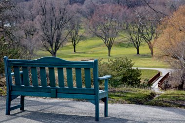 Golf sahasının yüksek açılı manzarası ve parktaki bank.