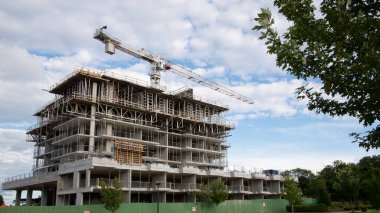 Vinçleri olan ve bulutlu bir gökyüzünde inşaat alanı