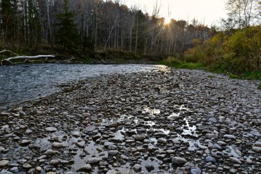 Milli Park 'taki taşlarla nehir kenarının güzel günbatımı manzarası 