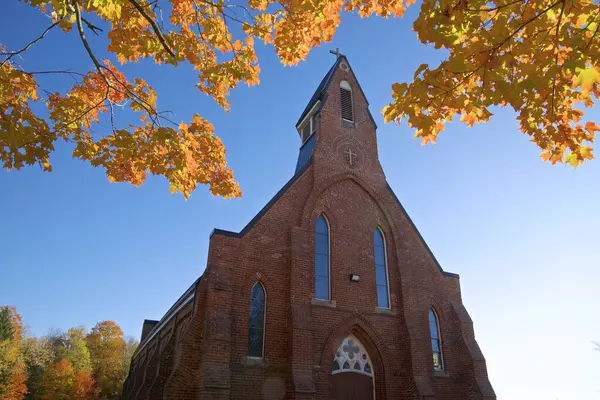 Low angle view of a rural community church with autumn leaf colour