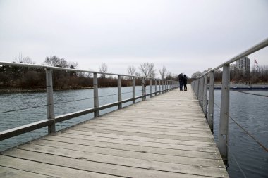 Toronto göl kıyısında köprüde yürüyen bir çift..