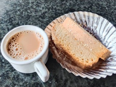 İnek sütü, şeker ve çay yapraklarından oluşan bir fincan süt tozu ve çok amaçlı kullanım için tost.