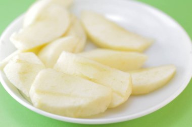 Taze kesilmiş elma parçaları bir tabakta duruyor.