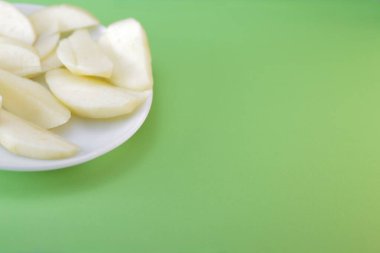 Taze kesilmiş elma parçaları bir tabakta duruyor.