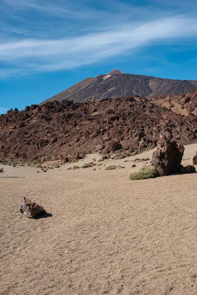 stock image Vertical landscape of volcano el teide with rocks and sand in foregound during sunny summer day in tenerife, spain