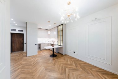 Ahşap zeminli yeni bir ışık evinde hafif mobilyaları olan bir stüdyo mutfağı.