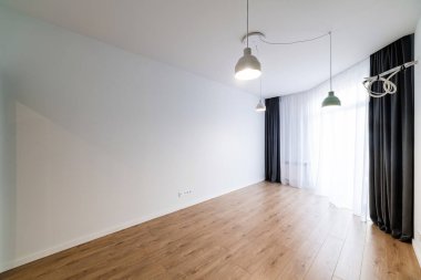 Geniş pencereli ve perdeli temiz, aydınlık bir oda.