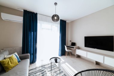 Geniş pencereli ve mobilyalı yeni bir binada bir stüdyo mutfağının iç tasarımı.