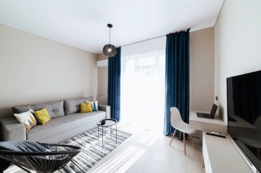 Geniş pencereli ve mobilyalı yeni bir binada bir stüdyo mutfağının iç tasarımı.