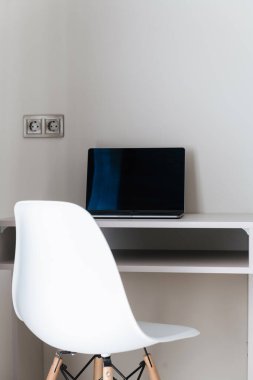 Bilgisayar, dizüstü bilgisayar ve beyaz sandalyede çalışmak için bir yer.