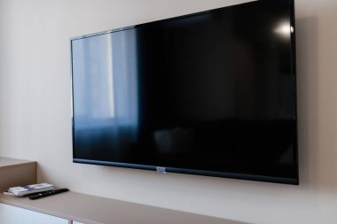 Apartmanın duvarında yeni bir siyah televizyon asılı.