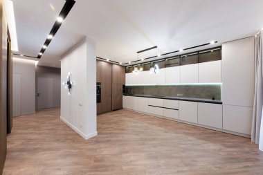 Beyaz ve koyu cepheli ve ışıklandırmalı yeni şık mutfak.