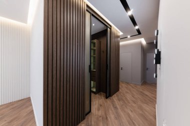 Karanlık zemini ve doğal ahşaptan yapılmış bir dolabı olan bir evde tasarımcı.