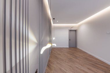 Yeni evde gri beyaz duvarlı büyük boş bir oda.