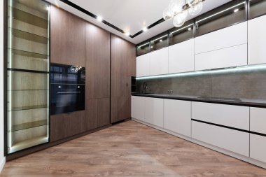 Beyaz ve koyu cepheli ve ışıklandırmalı yeni şık mutfak.