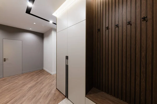 interior design of a hallway with a white cabinet and a hanger made of wood