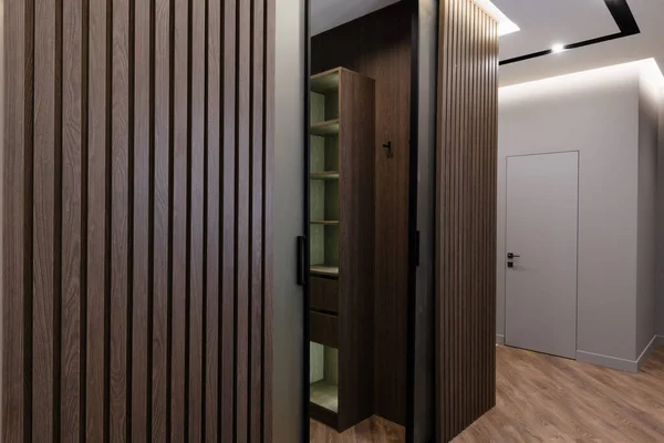 designer interior in a house with a dark floor and a wardrobe made of natural wood