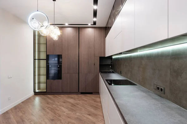 interior design of a large studio kitchen with light and dark facades