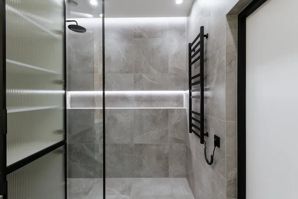 Gri kiremitleri ve cam duş duvarı olan banyo iç tasarımı