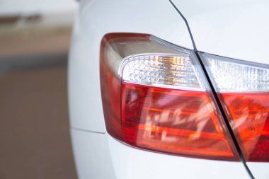 Park halindeki bir otomobilin arkasındaki kırmızı fren lambasının yakın görüntüsü. LED ışıklandırmalı arka lamba araçlar için çok önemli bir güvenlik özelliğidir..