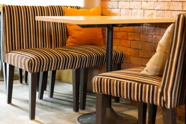 Ahşap Mobilya ve Tuğla Duvarları ile rahat ve şık Kafe İçi, Akşam Yemeği, Sosyalleşme veya İş Toplantıları İçin Sıcak ve Davetkar bir atmosfer Sağlama