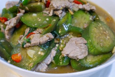 Kırsal bir ahşap masa üzerinde bir kasede sunulan leziz ve lezzetli biftek ve sebze güveci Lezzetli ve besleyici bir ev yemeği sunuyor.