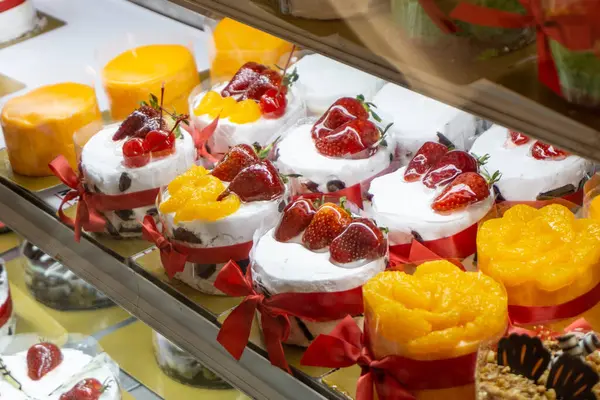 stock image Assortment of Delectable Desserts on Display in a Bakery or Cafe Setting,including Cupcakes,Cakes,and Fruit-Topped Pastries Arranged Beautifully on a Tray or Plate