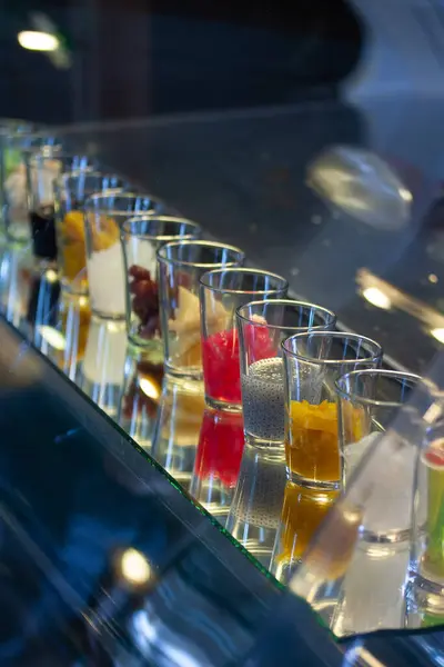 stock image Assortment of Colorful Alcoholic Cocktail Drinks Served on a Bar Table for a Nightlife or Happy Hour Event. Variety of Glassware with Garnishes in a Lively,Vibrant Setting.