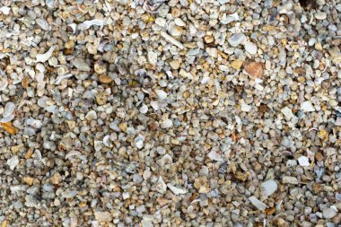 Doğal çakıl taşı, çakıl taşı ve kaya yüzey dokusu arkaplanının detaylı makro fotoğrafı. Granüler, kaba ve granüler zemin veya toprak deseni.