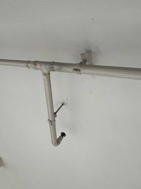 Metal şebeke benzeri çerçeve, tavanı destekleyen boş, minimalist endüstriyel bir iç mekan. Mimari tasarım, metal kirişler ve desteklerin geometrik, kafes benzeri bir modeline sahiptir..